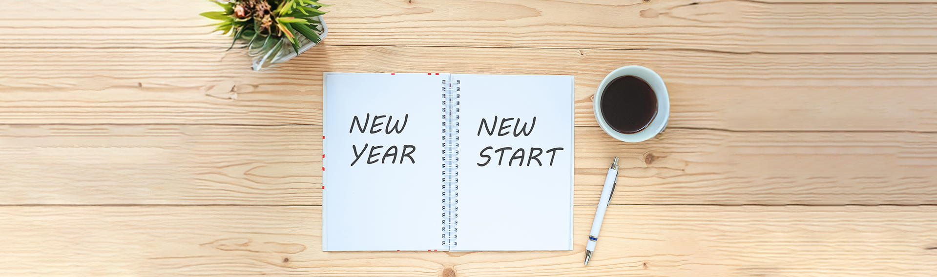 Photo of notebook on top of table with writing New Year, New Start